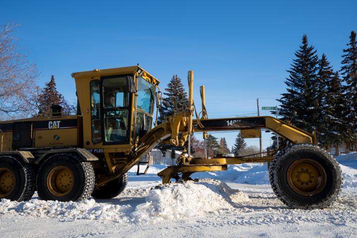 grader plowing snow